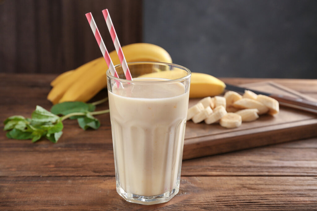 Milk-shake dentro de um copo transparente com decoração de bananas
