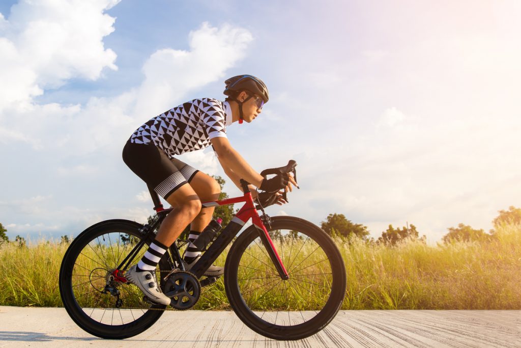 Ciclista de capacete sobre bicicleta em paisagem natural