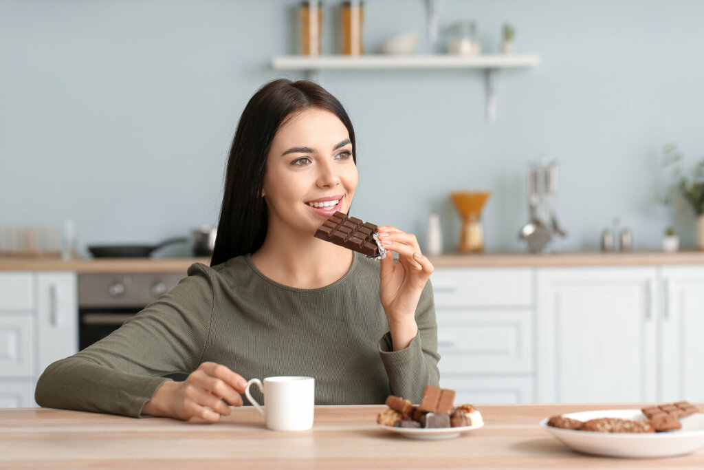 Mulher sentada comendo chocolate 