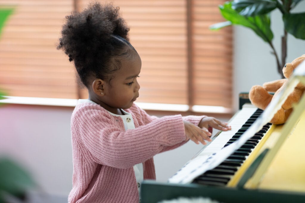 Criança pequena tocando piano sozinha
