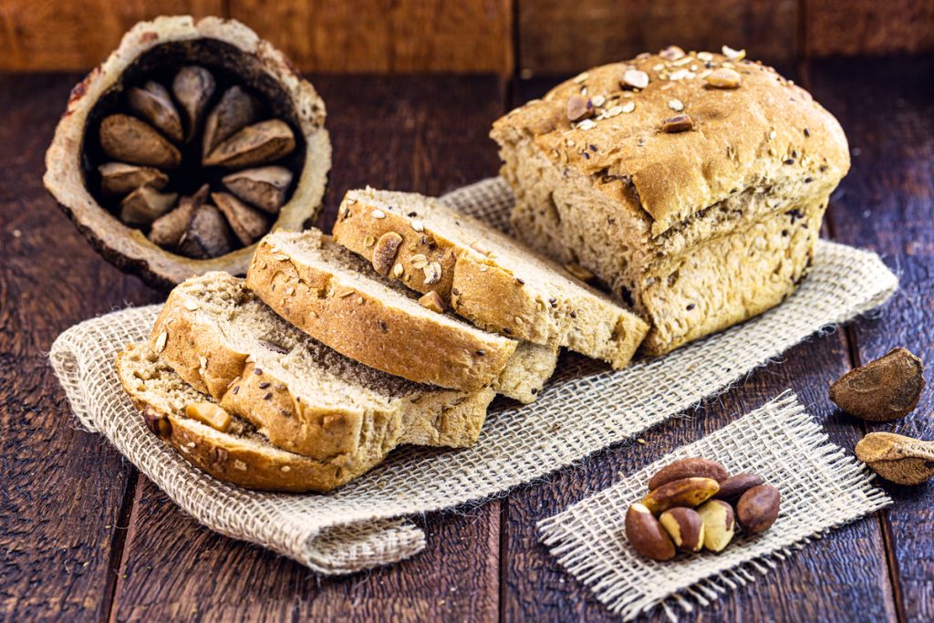 Pão com castanha em cima de um pano em uma mesa de madeira