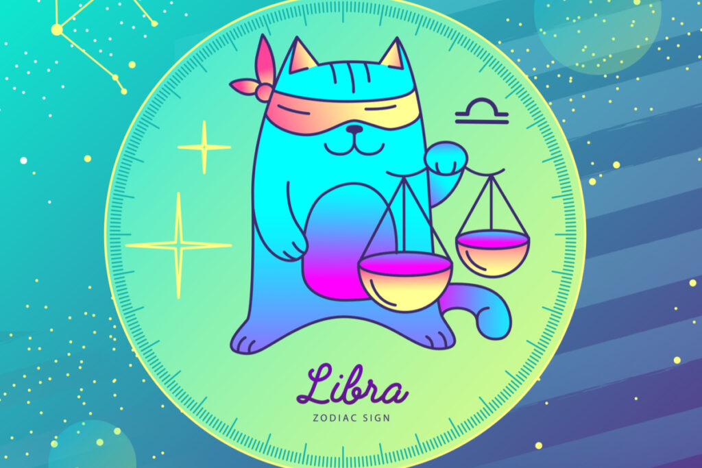 Gato segurando uma balança do signo de Libra