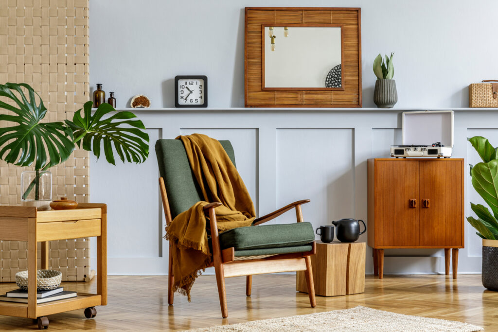 Sala com cadeira, vaso de planta e objetos decorativos ao redor