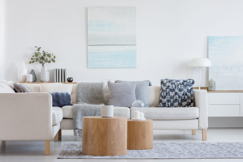 Sala de estar com sofá, almofadas, mesa de centro, quadros na parede e objetos decorativos