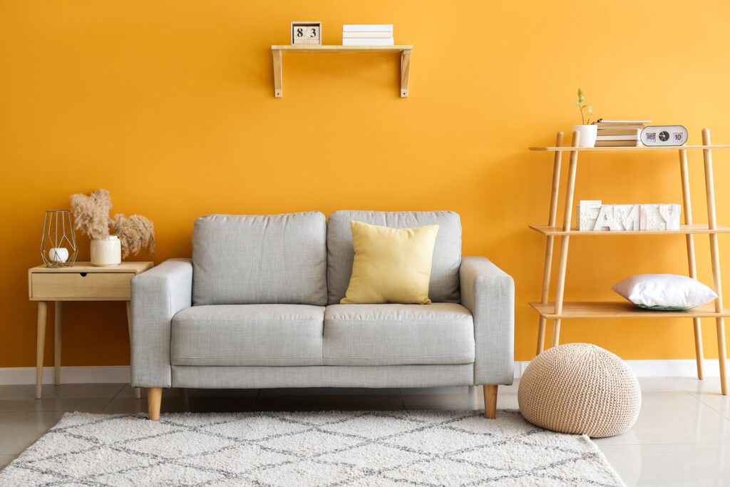 Sala de estar com parede laranja e sofá bege 