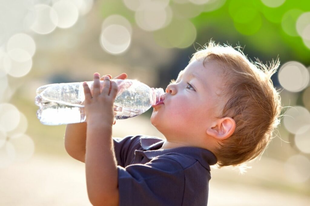 Criança bebendo água em garrafinha
