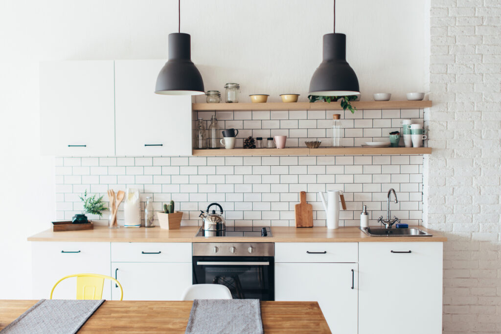 Cozinha multifuncional pequena e bem decorada, com armários brancos e marrons