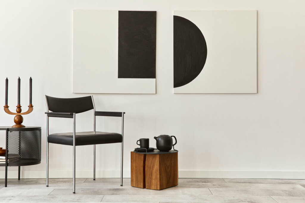 Cadeira preta ao lado de uma mesa de madeira com quadro branco ao fundo 