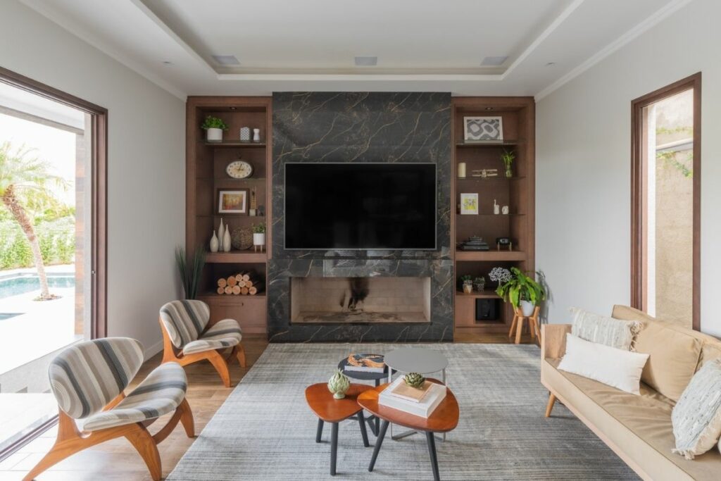 Sala de estar com móveis em madeira, lareira e tapete cinza