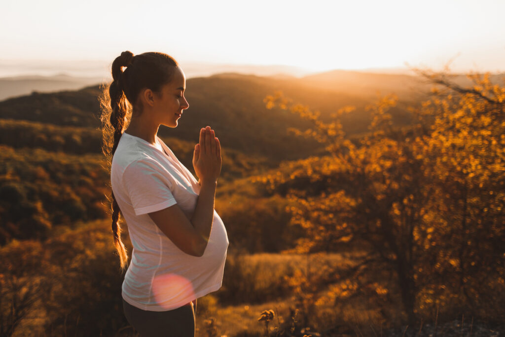 Mulher grávida meditando na natureza