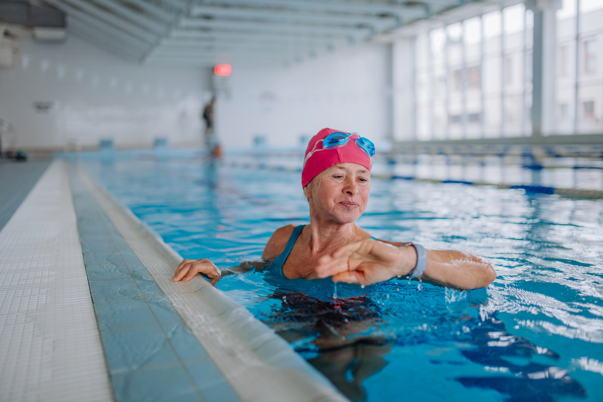 Mulher em uma piscina olhando para um relógio