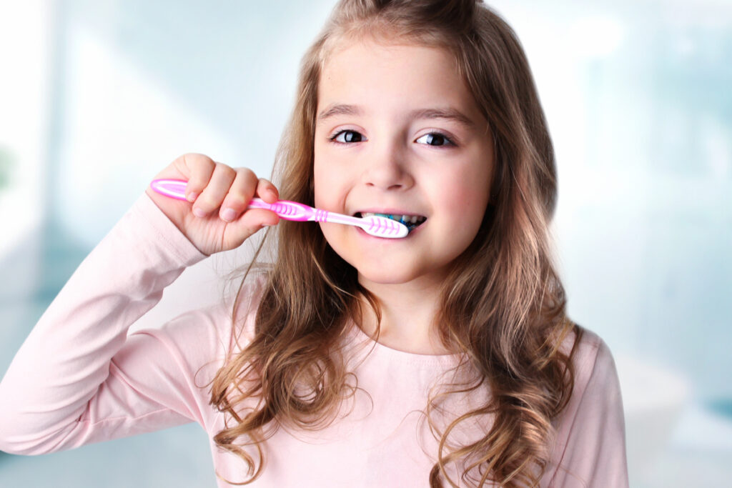 Menina escovando os dentes com escova