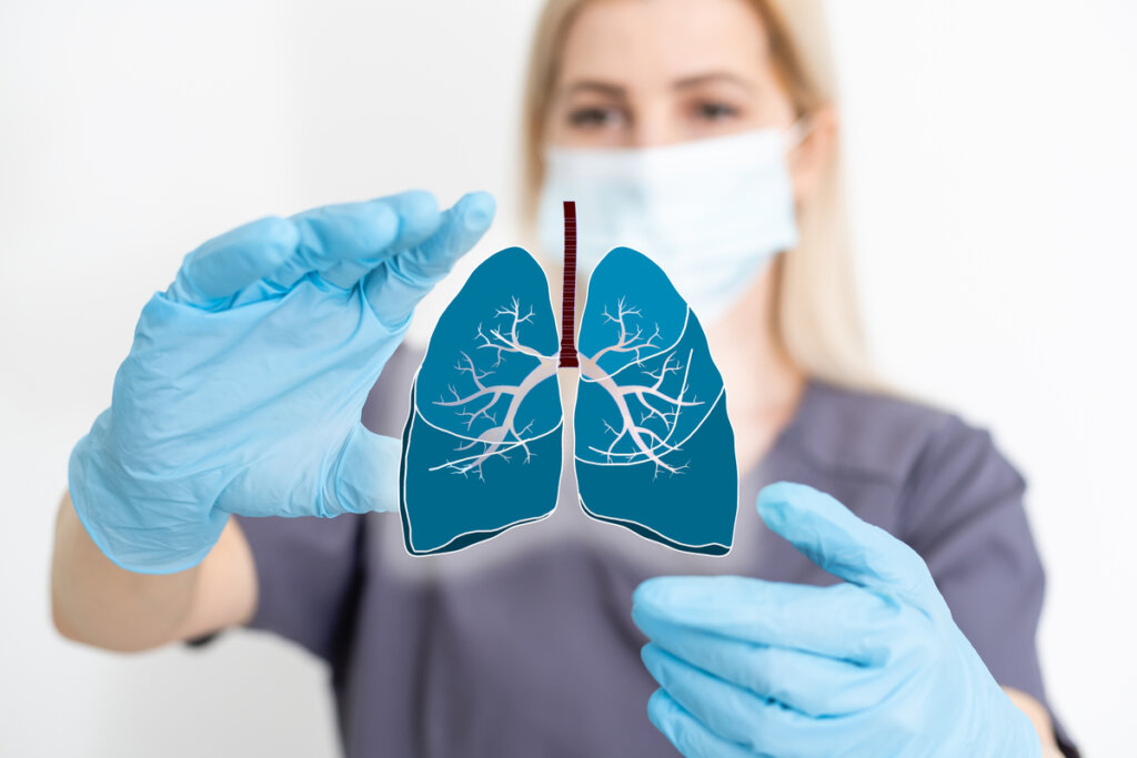 Médica com mãos em volta de uma ilustração de pulmões