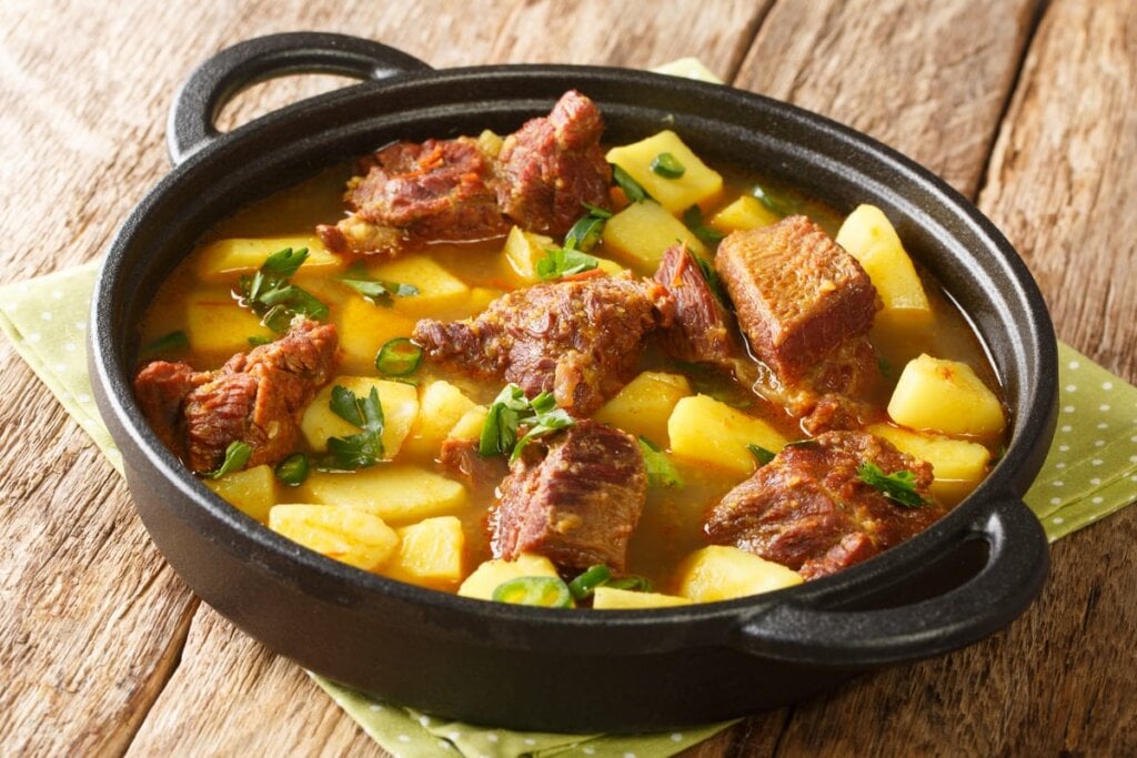 Carne com batata e cheiro-verde em panela preta