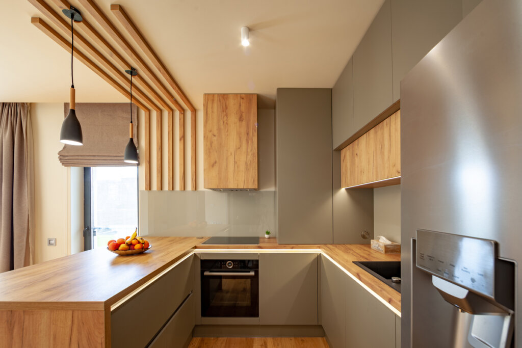 Cozinha com bancada de madeira e armários cinza 