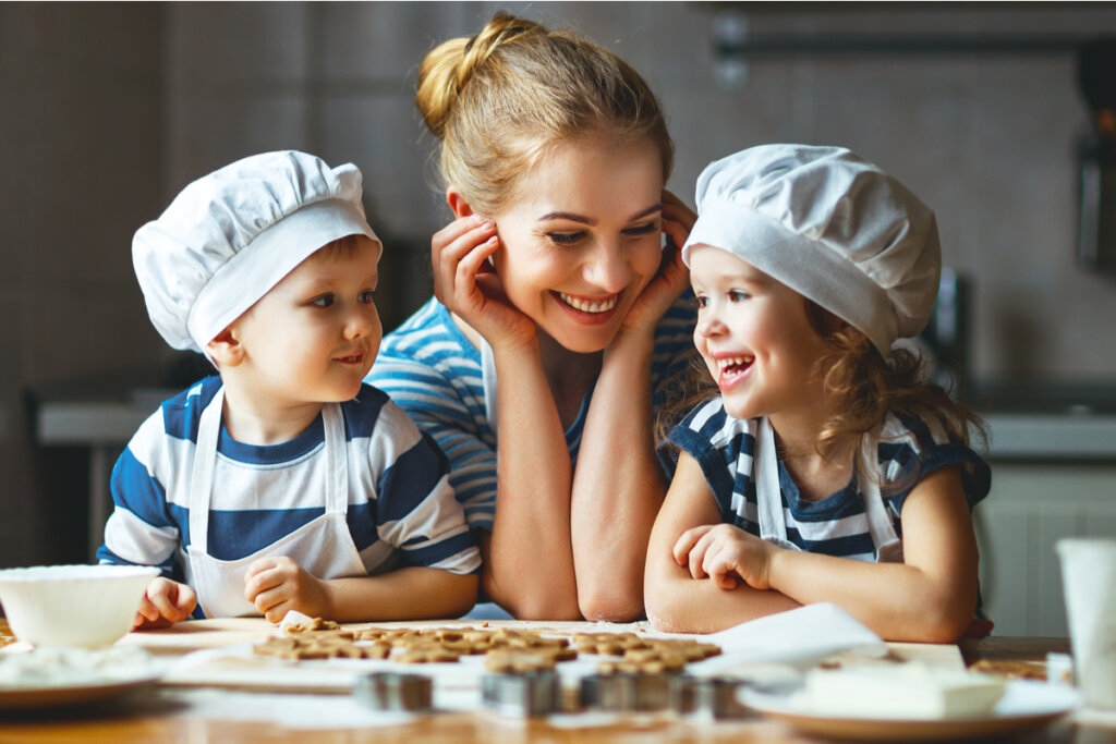 Crianças com chapéu de cozinheiro cozinhando com a mãe
