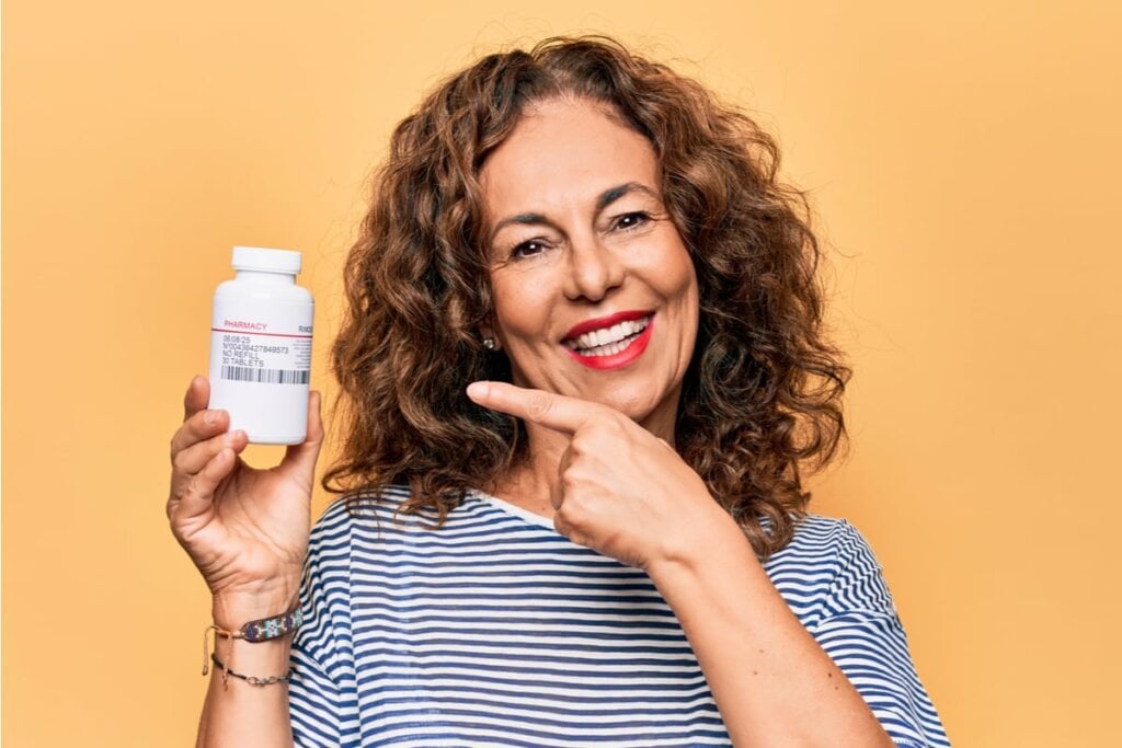 Mulher sorrindo apontando para remédio