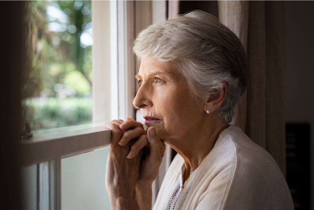 Mulher de meia idade olhando através de uma janela