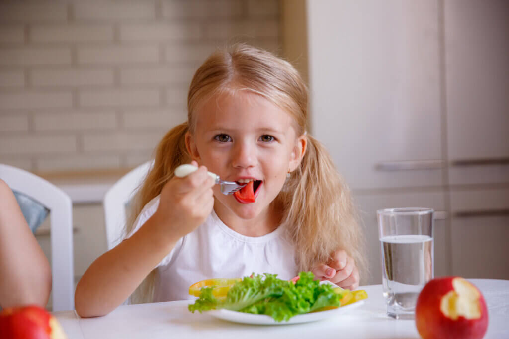 Criança sentada e comendo saudável
