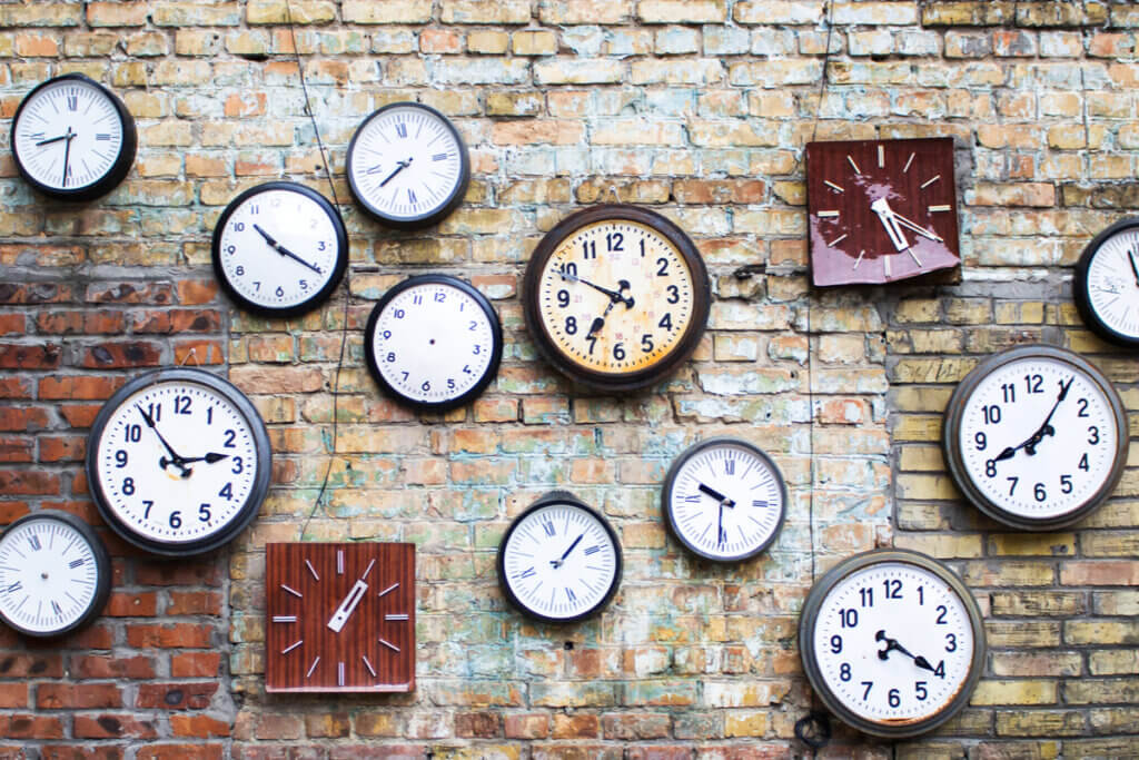 Coleção de relógios vintage pendurados em uma parede de tijolos velha