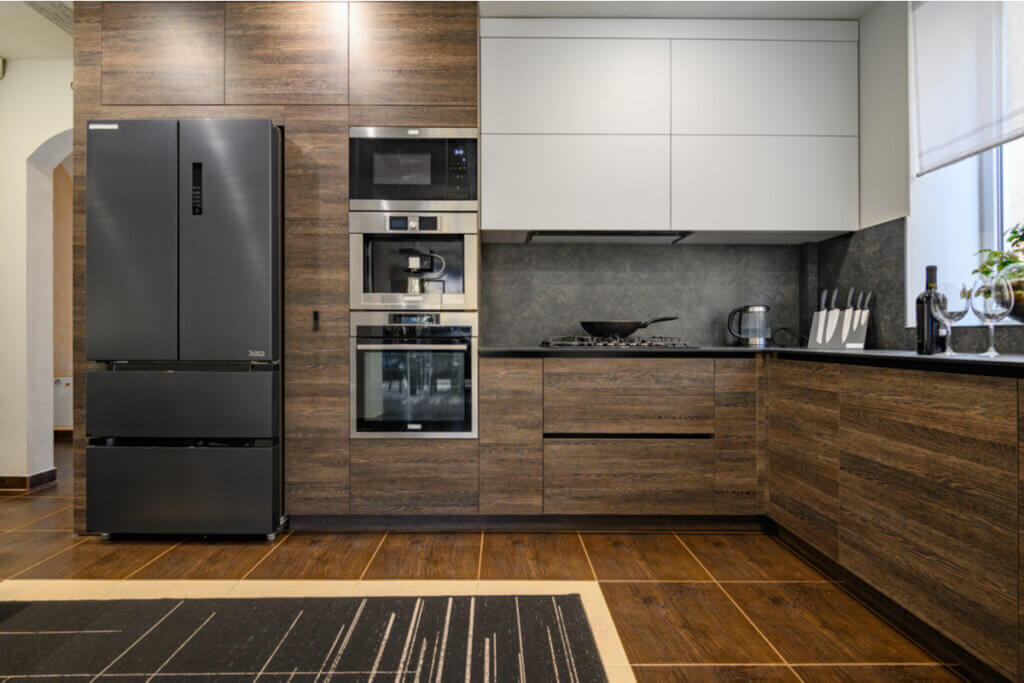 Cozinha com armários em madeira, geladeira e utensílios de cozinha