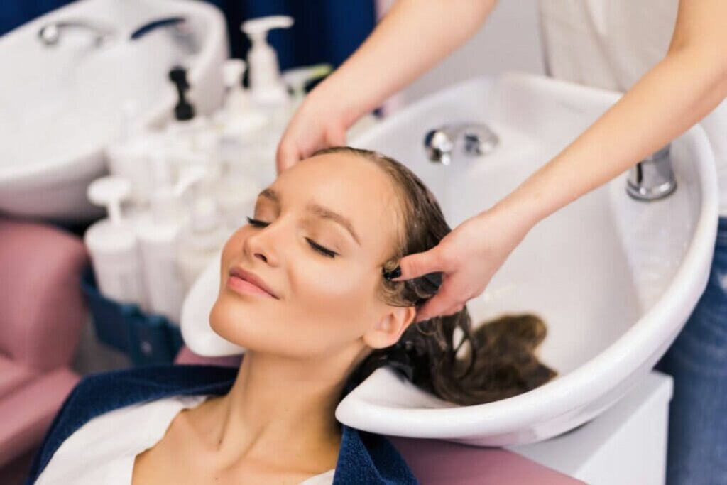 Mulher lavando o cabelo em lavatório