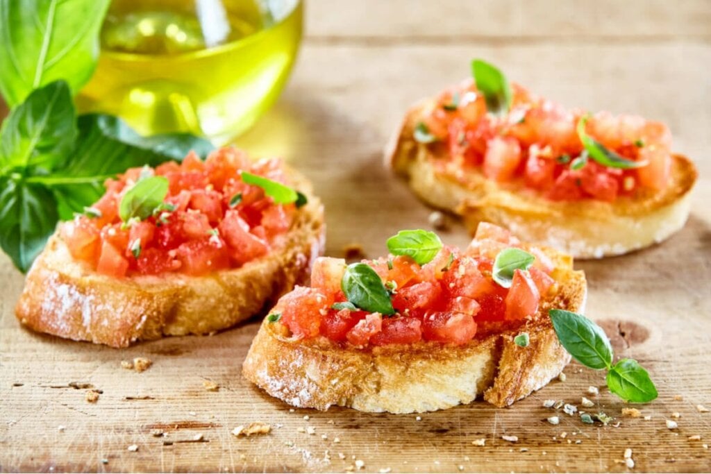 Pedaços de pão com pedaços de tomate decorado com folhas de manjericão