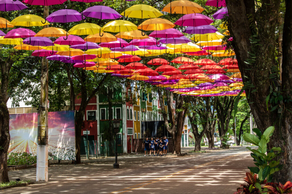 Rua enfeitada com guarda-chuvas coloridos