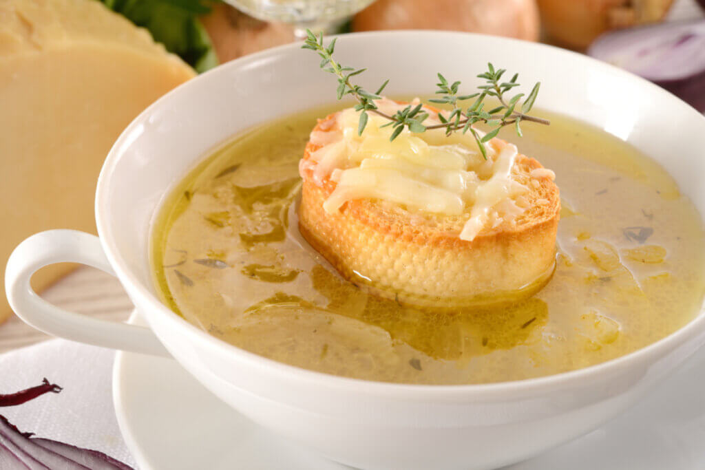 Sopa com cebola decorada com pão tostado e queijo parmesão