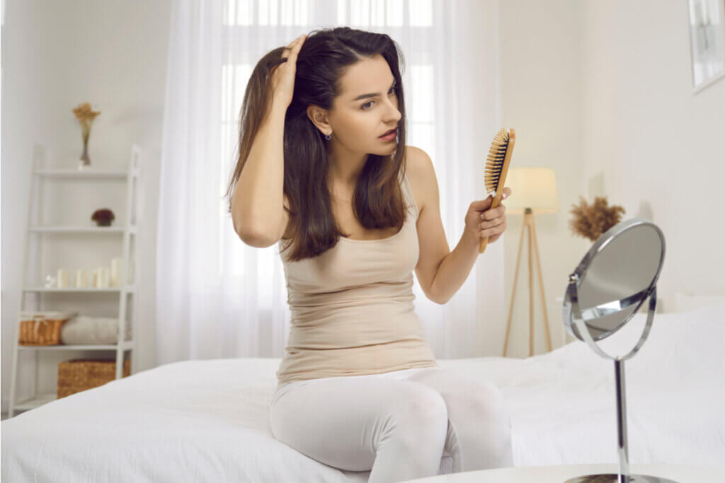Mulher olhando o couro cabeludo em um espelho 
