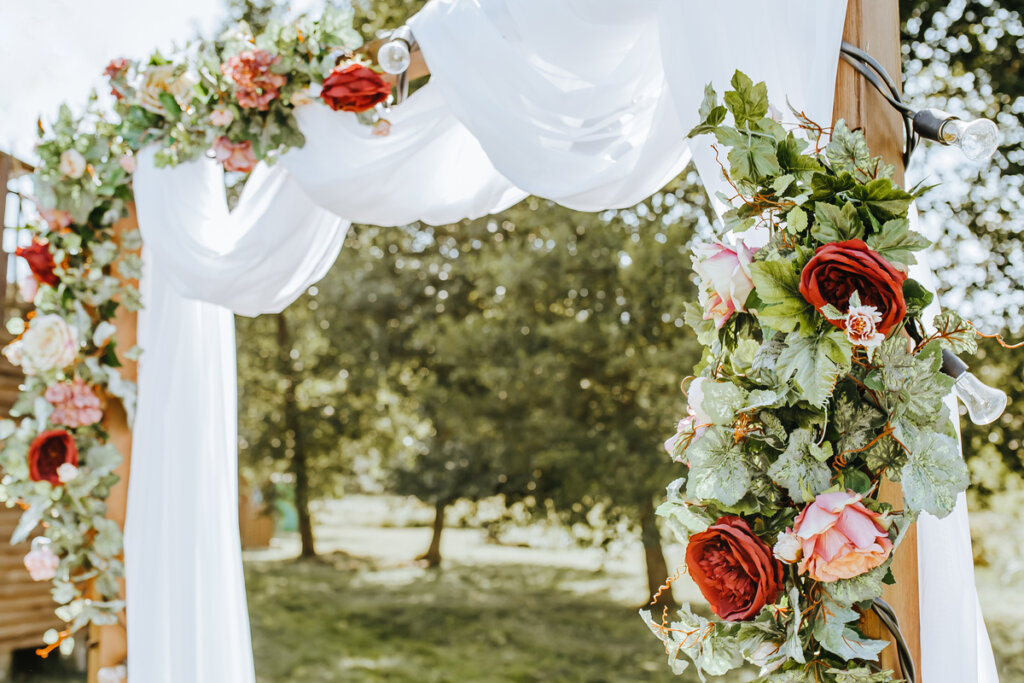 Entrada de uma festa de casamento ao ar livre com flores na decoração