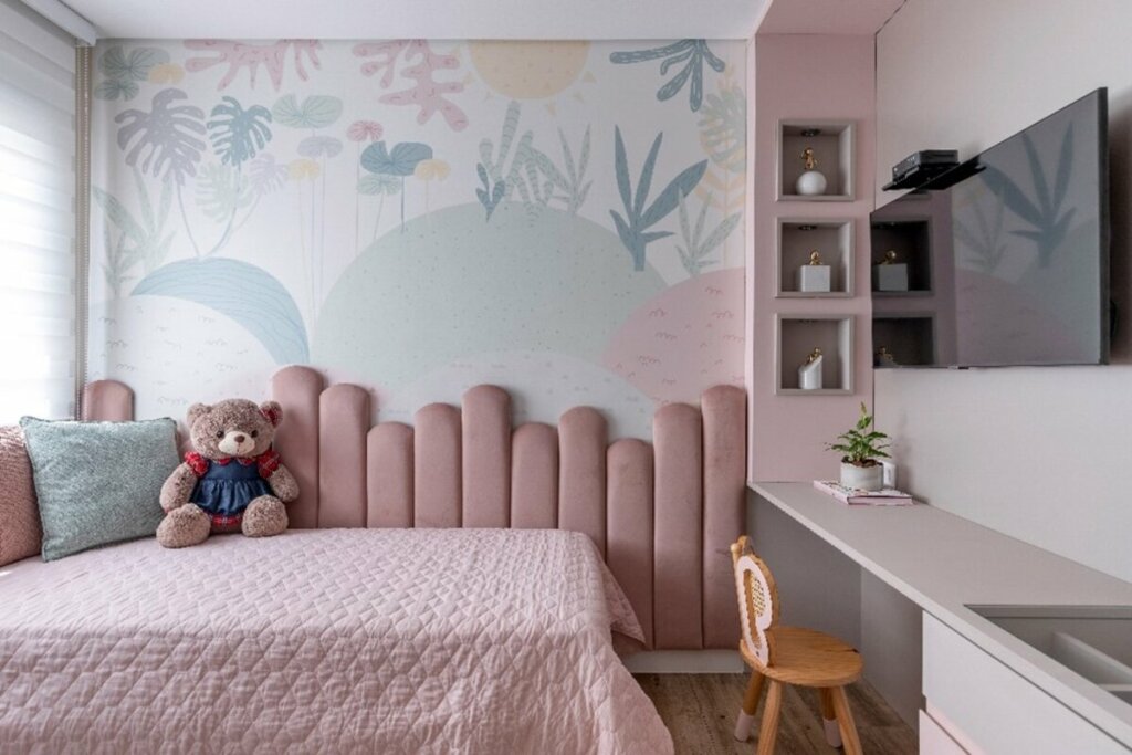 Quarto de criança com uma cama, cabeceira rosa e brinquedos