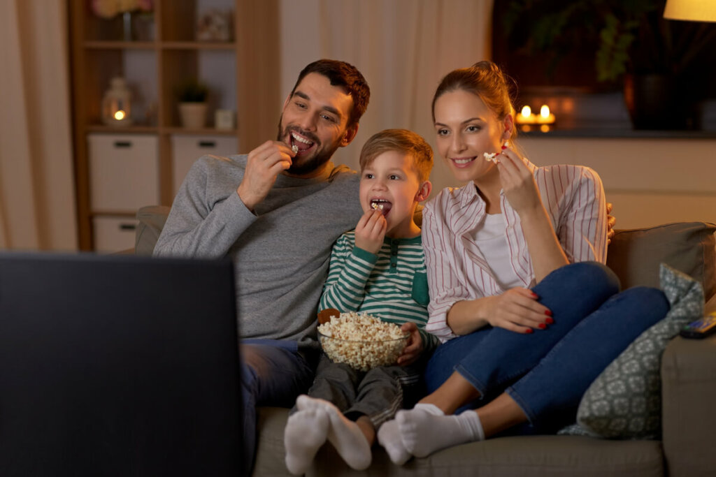 Família assistindo a um filme comendo pipoca