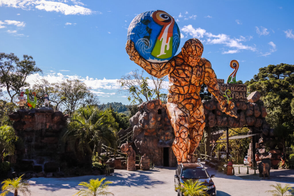 Entrada do Parque Terra Mágica Florybal, em Canela, com estátua de um homem de pedra segurando uma bola 