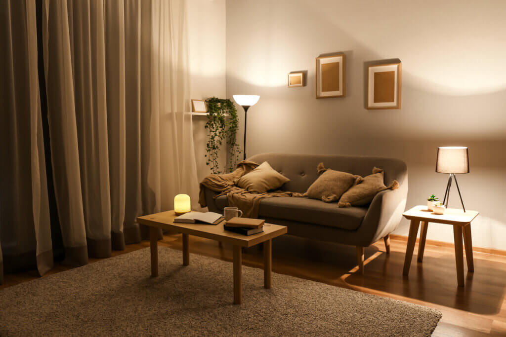 Sala com sofá, mesa de centro, quadros na parede e iluminação