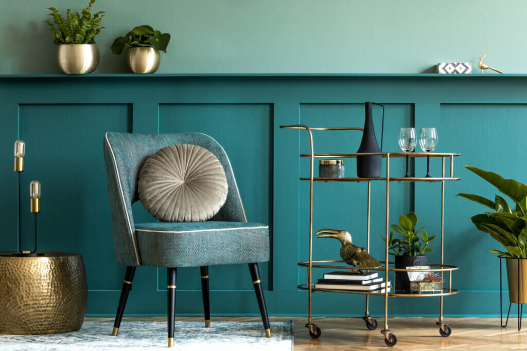 Ambiente com sofá azul, vasos de plantas e mesa com objetos decorativos