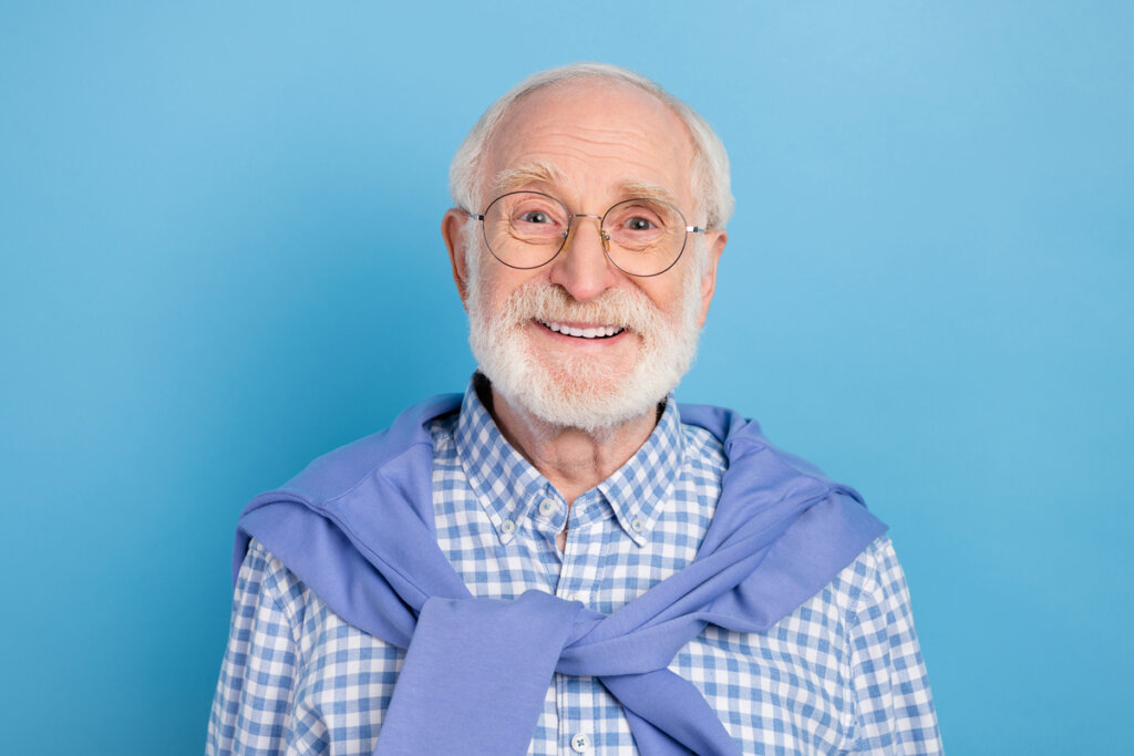 Homem idoso de óculos e blusa xadrez sorrindo