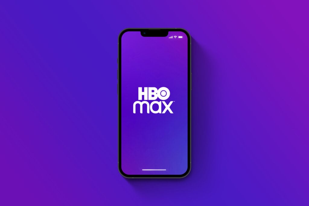 Celular com logo da hbo max no fundo roxo