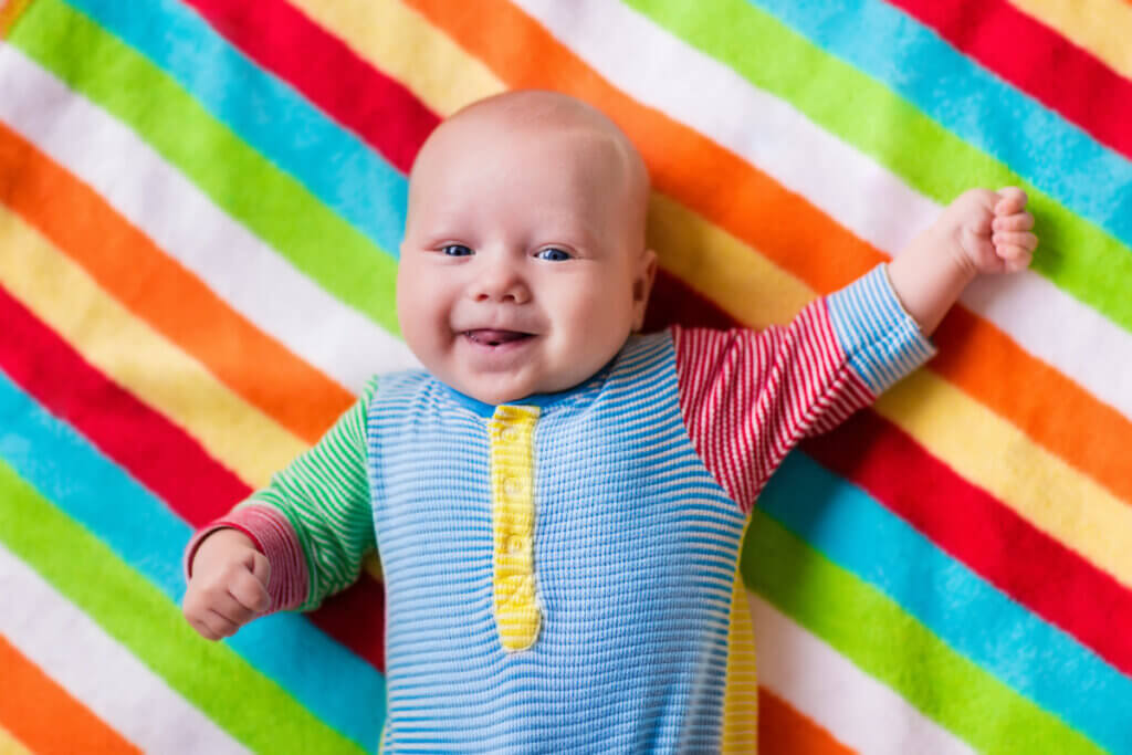 Bebê com roupa colorida sorrindo