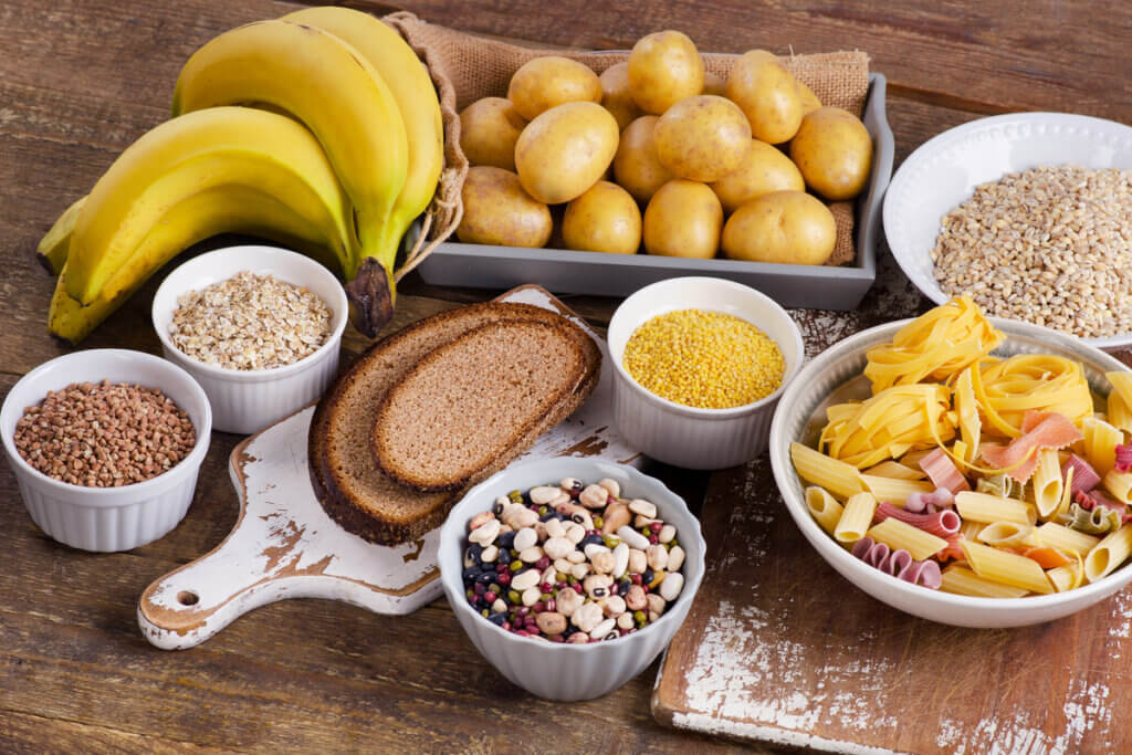 Mesa com pão, banana, cereais, macarrão e batatas