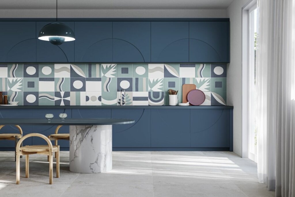 Cozinha com armários em azul, revestimentos estampados e mesa com marmore