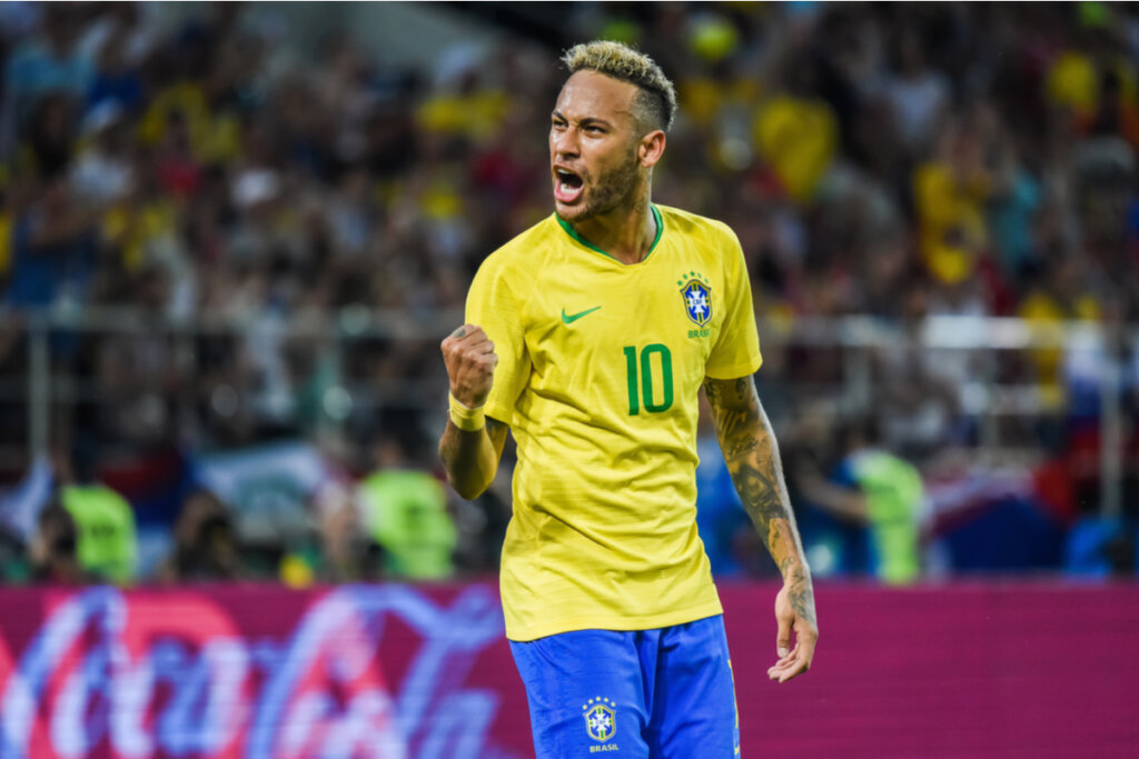 Neymar em campo vibrando e vestindo a camisa da seleção brasileira