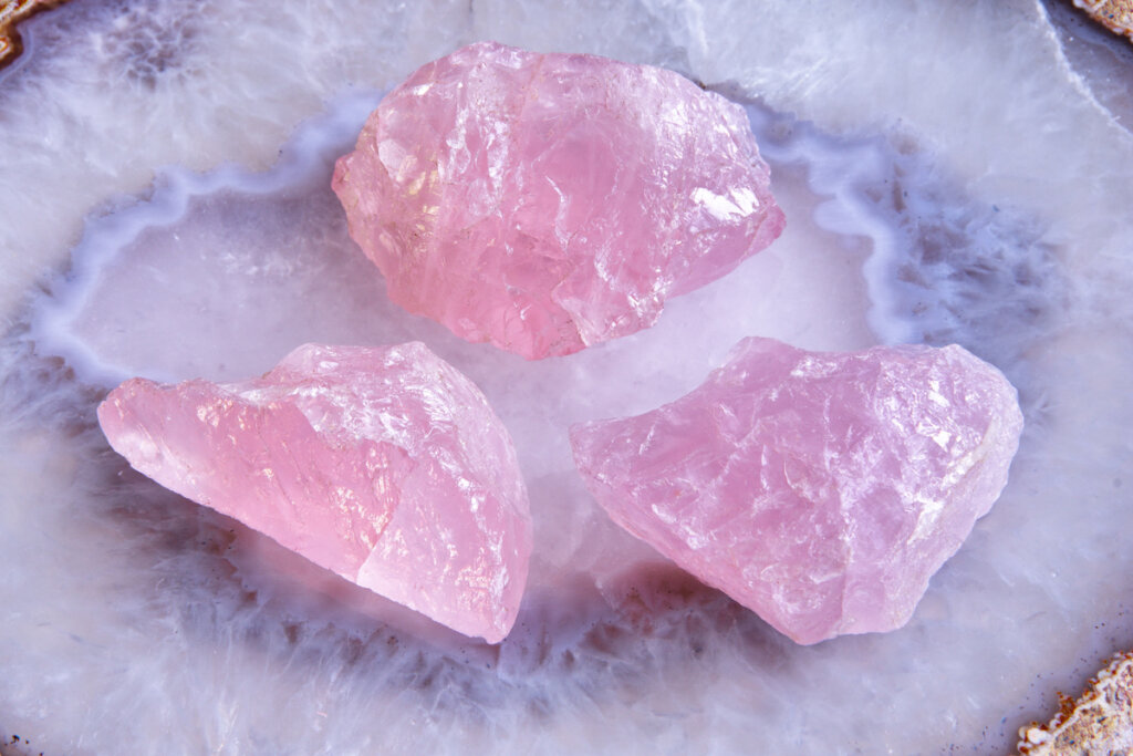 Três pedras de quartzo rosa em cima do mármore branco