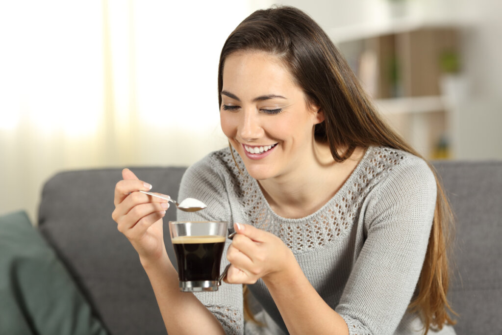 Mulher sorrindo adoçando café