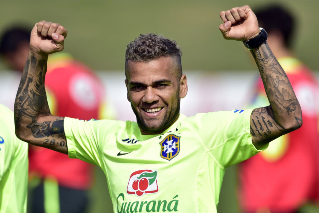 Daniel Alves com a camisa do Brasil com as mãos para cima