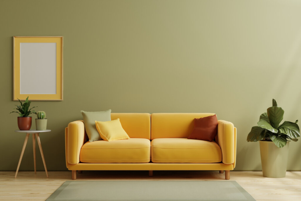 Sala de estar decorada com sofá amarelo e parede verde