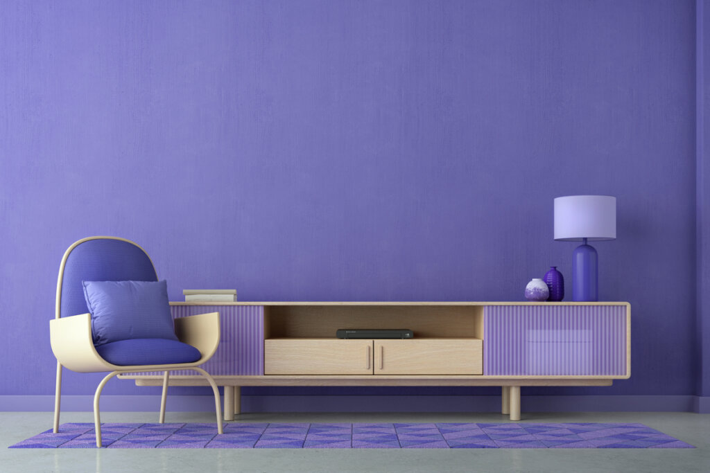 Sala de estar com poltrona violeta, móvel violeta e abajur violeta