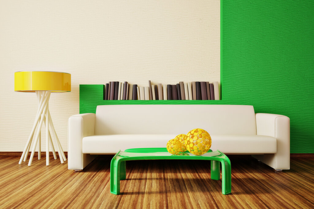 Sala de estar com sofá branco, mesa verde, abajur amarelo e parede verde