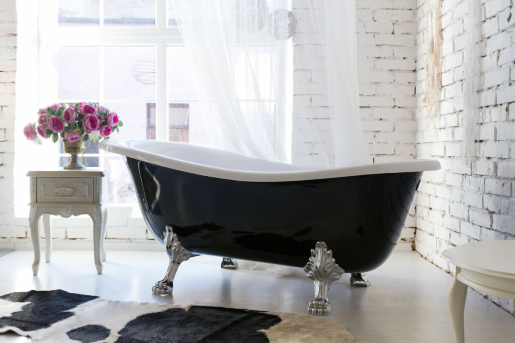 Banheira preta com pés de metal em um banheiro 