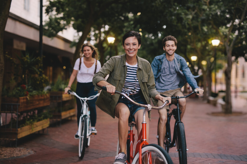 Três pessoas andando de bicicleta em um parque